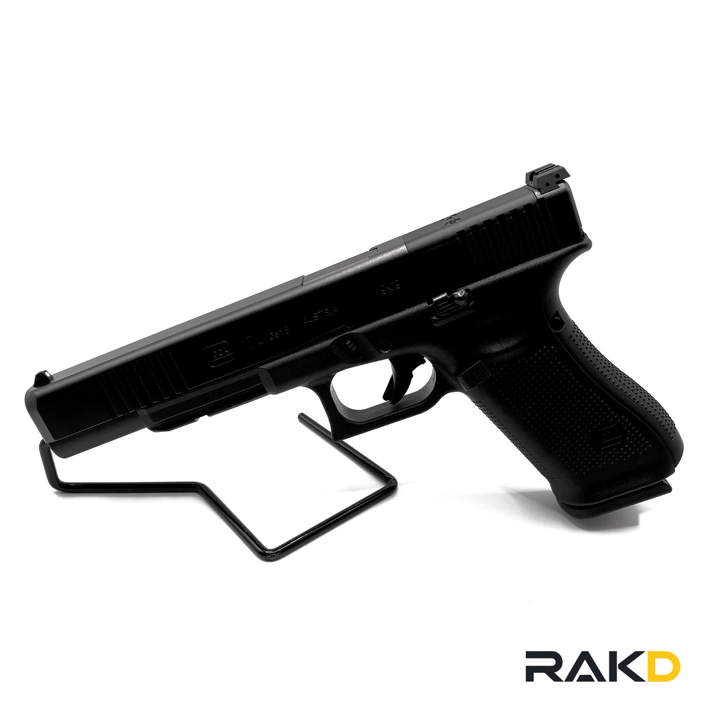 A black Glock pistol on a wire stand, muzzle forward, the slide marked 9x19 and Austria, with a flat-faced trigger and no finger grooves on the frame.