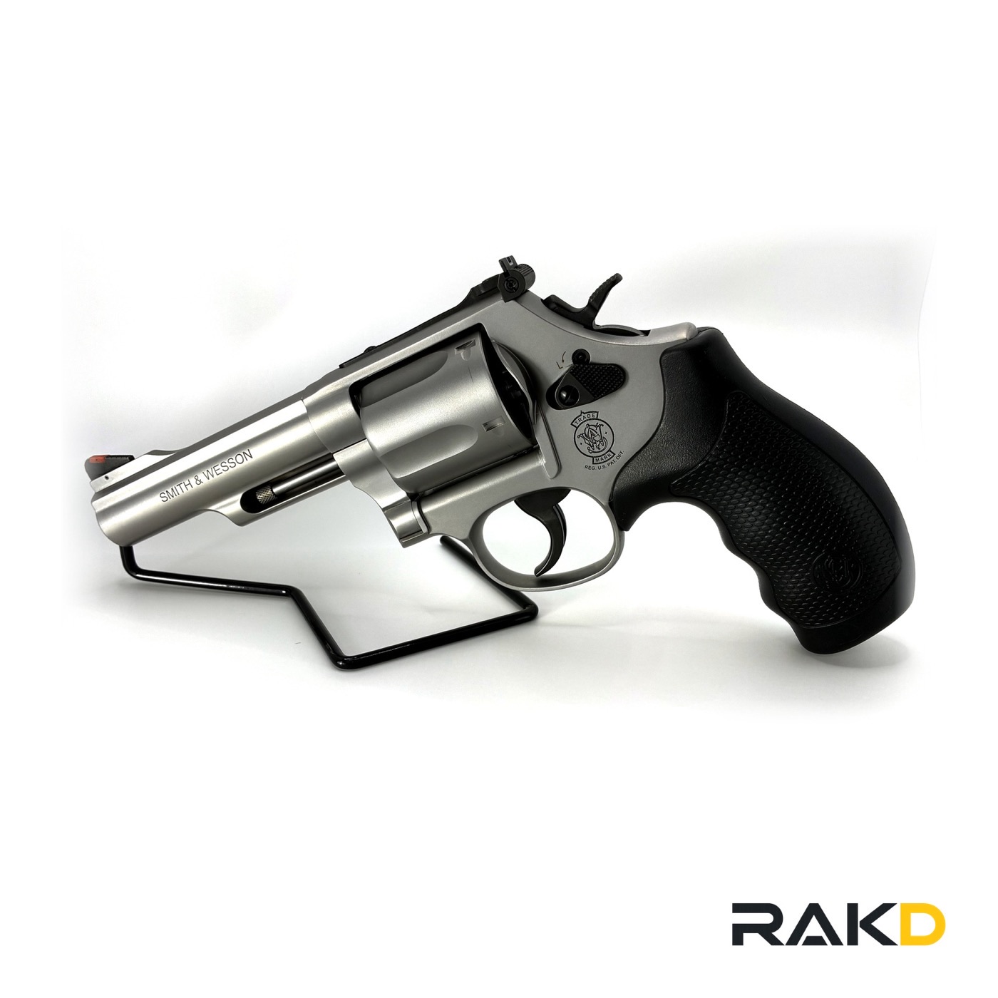A stainless Smith & Wesson revolver with a three inch barrel, black rubber combat grips, an adjustable rear sight and a red ramp front sight.